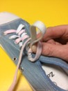 pinching the bottom of the shoe lace bow