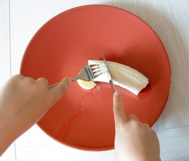 a child cutting a banana