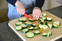 a child cutting a piece of food into small pieces